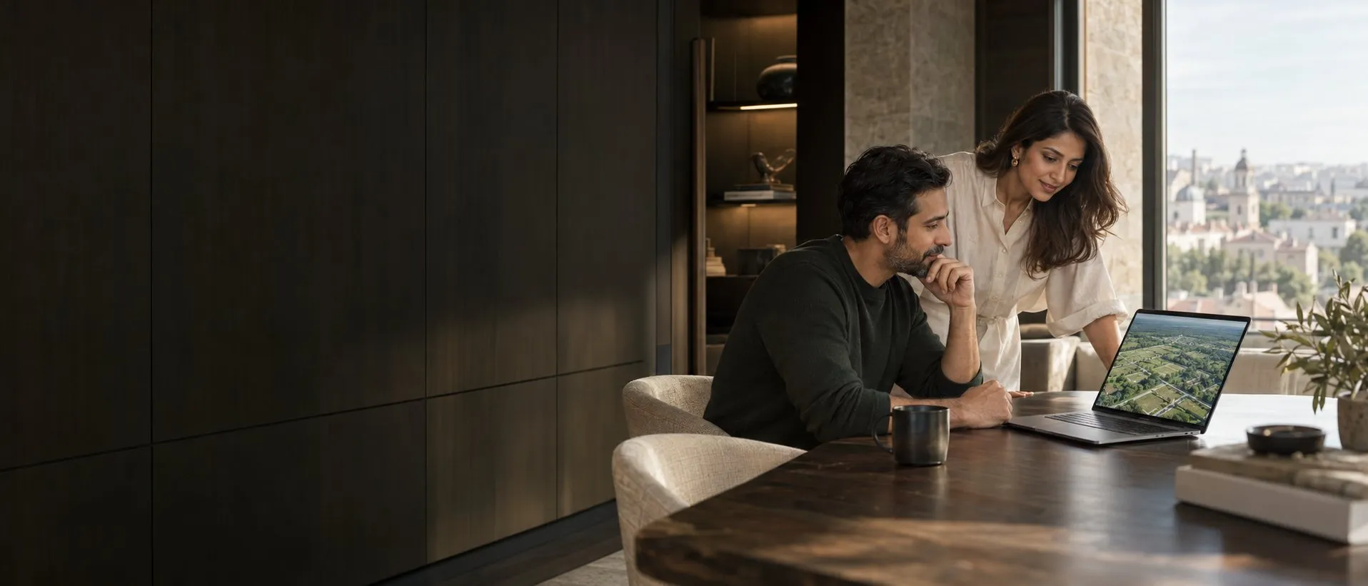 AI concept visualisation of a couple abroad reviewing an aerial view of plotted land on a laptop, in a refined apartment overlooking a city