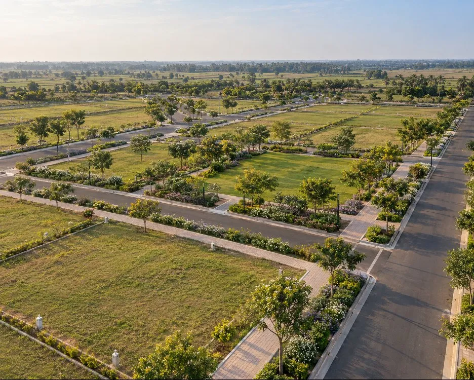 Concept visualisation of an aerial view of an organised plotted layout, with tree-lined internal roads, open plots and a central landscaped green